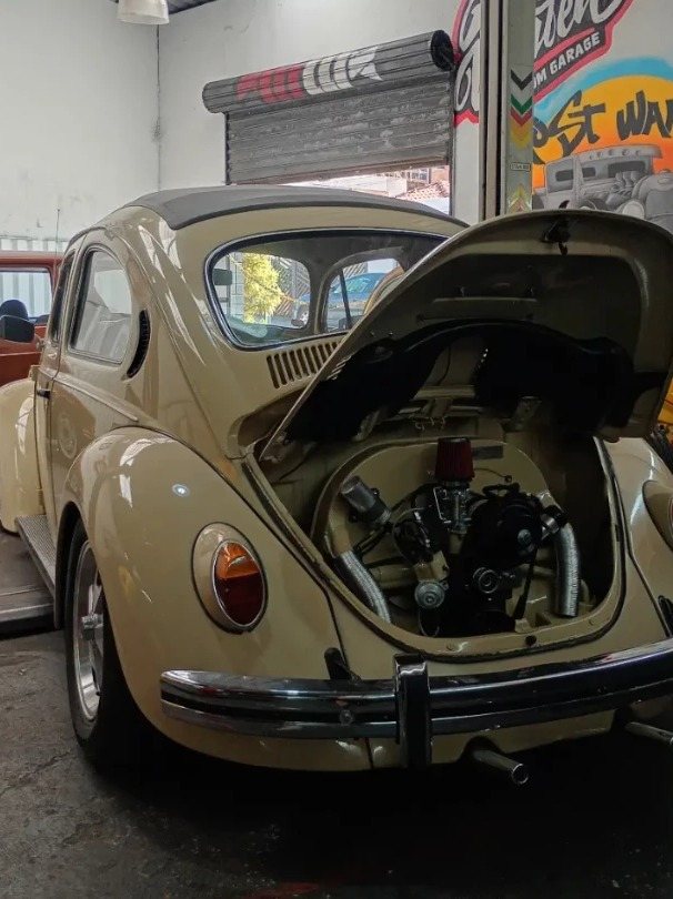 Fusca bege com a tampa do motor aberta