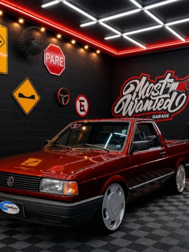 Saveiro vermelha rebaixada no estúdio, com o logo Most Wanted na parede